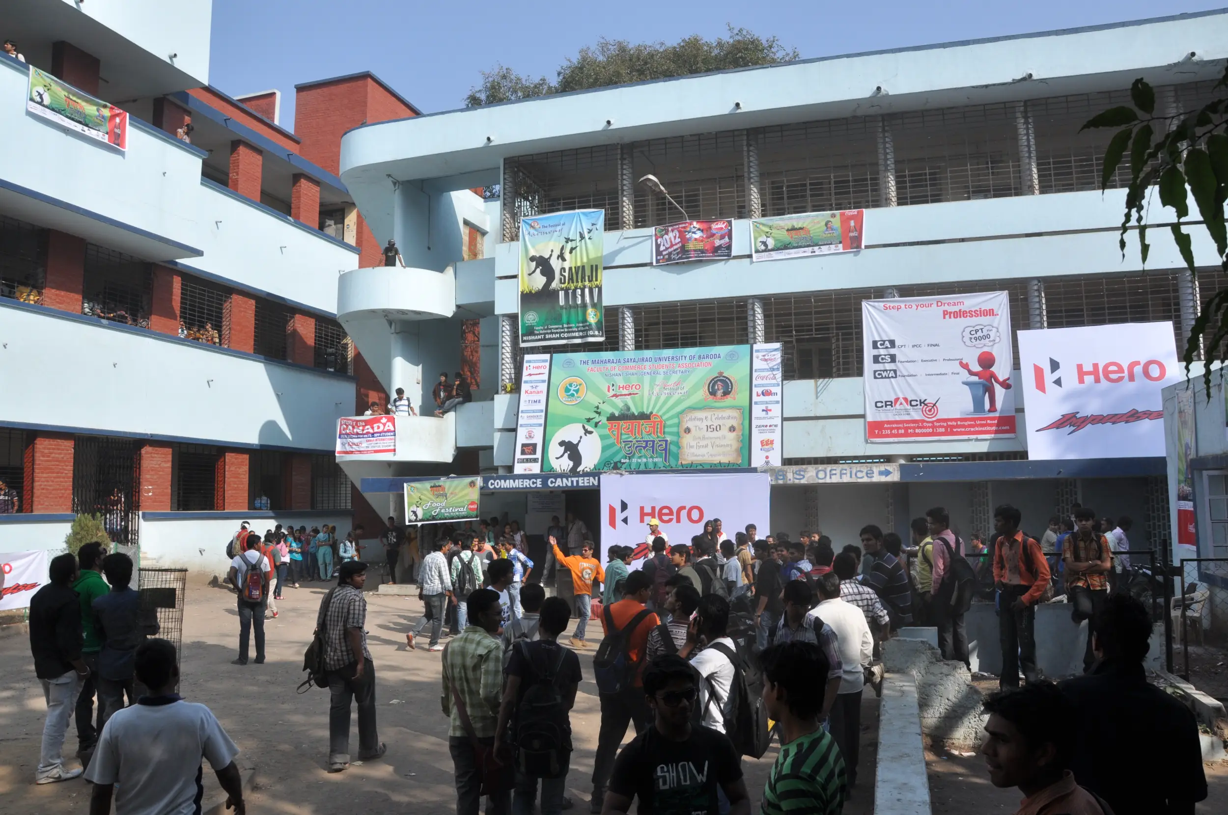 Balloon arch in orange, black, and white colors framing an ITT logo board lit with warm lights